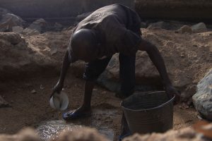 Dokumentarfilm 'Klimafluch und Klimaflucht' - Afrikaner graebt nach Wasser