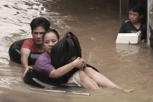 Dokumentarfilm 'Klimafluch und Klimaflucht' - Überschwemmungen in Indonesien, Menschen im Wasser
